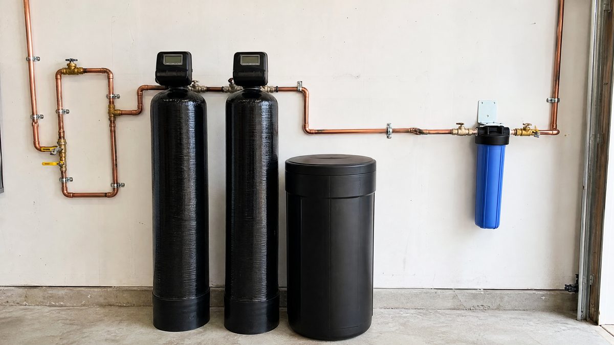 Whole-home water softener and filtration system with copper piping and bypass installed in a Hollister garage
