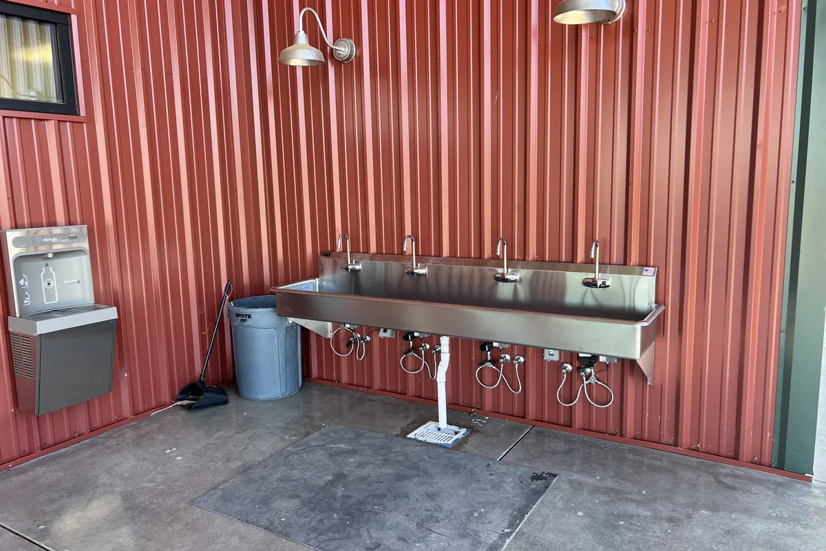 Multi-station stainless wash sink plumbed and set for a Central Coast commercial facility.