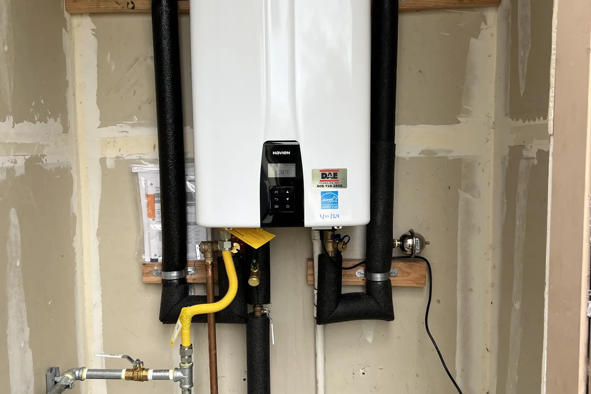 Replacement tankless unit installed with clean gas, venting, and isolation valve connections on a Hollister service call.