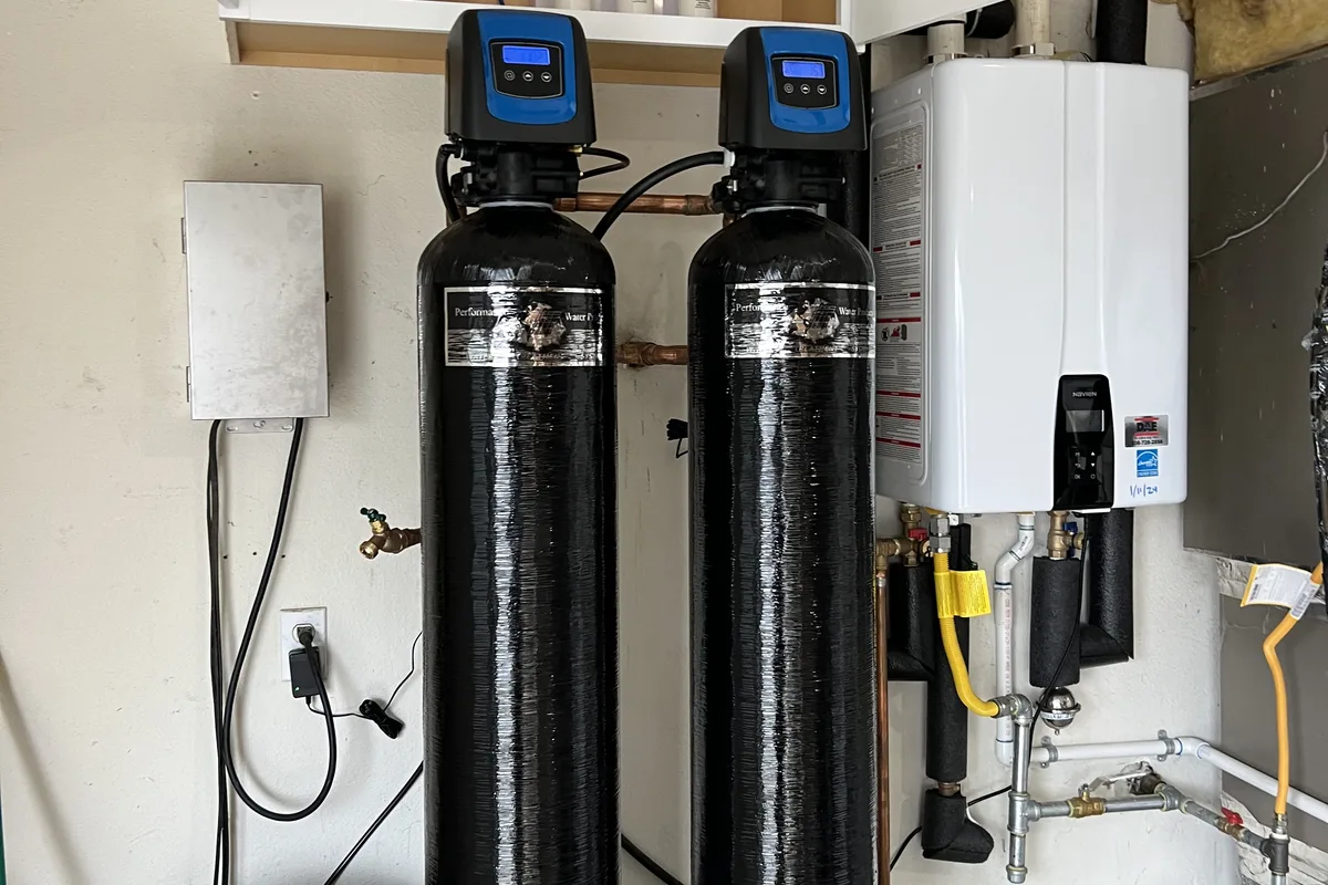 Utility room upgrade combining a new tankless water heater with a multi-stage water treatment system.